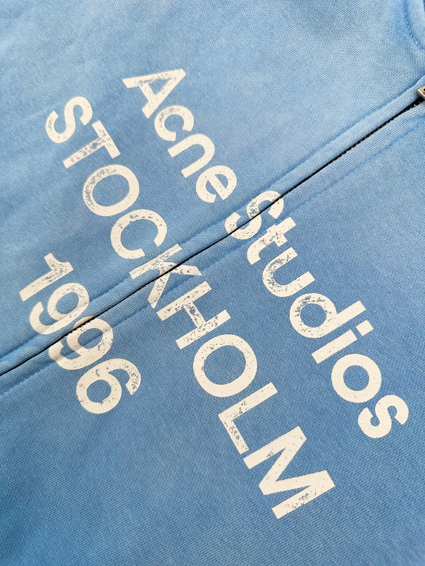 Acne Studios spray-painted distressed logo baseball collar jacket, custom-ordered soft velvet fleece, crisp and smooth, skin-friendly and soft, cornflower blue like clear sky velvet, matte matte flow, warm and luxurious light, showing high-end restrained texture. Classic baseball collar zipper jacket has a neat and noble silhouette. Dropped shoulders are cut for stretch and casualness. Close-woven ribbing shows craftsmanship details. Acne Studios logo printing on the chest. The brand heritage is engraved with Retro sports aesthetics. It is unassuming but highly recognizable. It is a subtle blend of Nordic minimalist style and Retro sports style. It is low-key and elegant with its own aura. Process 1: Adopt glue printing process. The chest printing has been modified three times by the film screen. Use glue liquid paint to print the pattern on the fabric. Bake the fabric to fix the printed pattern. Process 2: Gradient distressed spray-on process. Spray dyes of different colors on the surface of the fabric. Realize that the clothes will show rich color changes under different lights and increase the visual layering. Process 3: Many parts of the body are worn by pure manual regular positioning. Manual brush marks add texture and depth to the surface of the clothing to imitate the texture of natural wear. Process 4: The fabrics have been fermented and washed to have a better hand feel. Not easy to deform, not easy to shrink, not easy to fade, and maintain long-term beauty. Accessories: Customized 1:1 Acne zipper Customized 1:1 Acne trademark Fit: Loose fit Size: S M L XL Style: CC